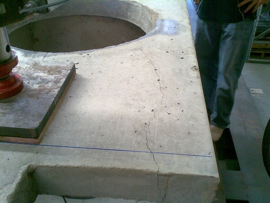 Synthetic fibre reinforced concrete test pit with opening